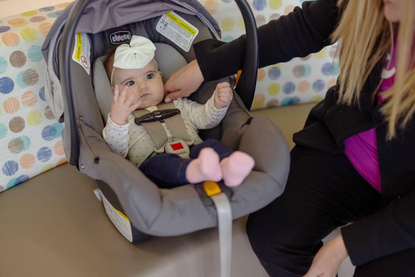 A parent tending to an infant in a car seat