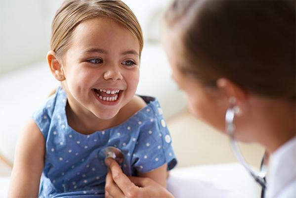 Doctor checking toddler's heart