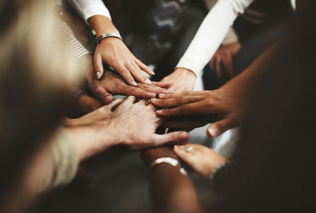 People putting their hands in the middle of a huddle
