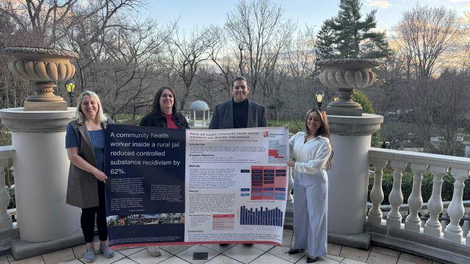 People presenting a banner with program information