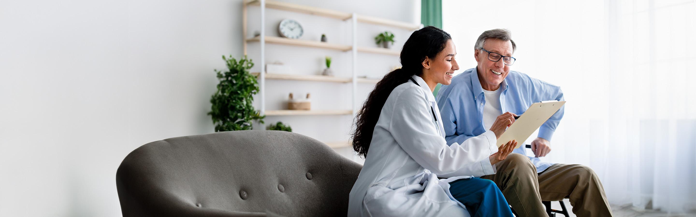 A caregiver reviews a chart with a patient who uses a wheelchair
