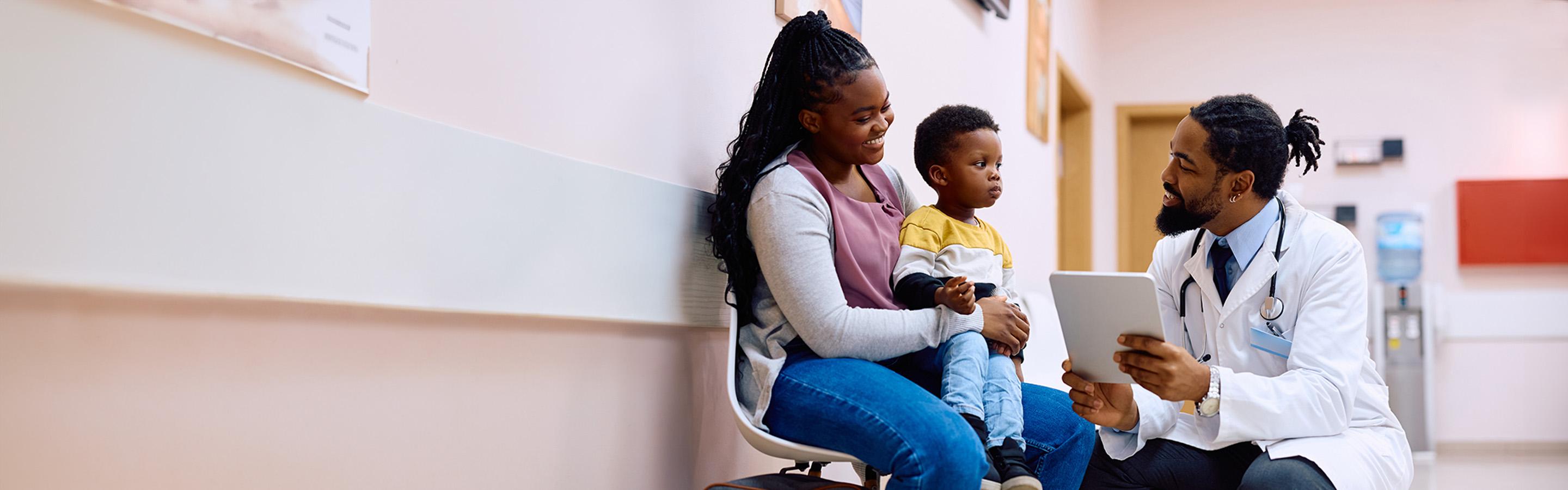 Doctor talking to mother and child in hospital waiting area