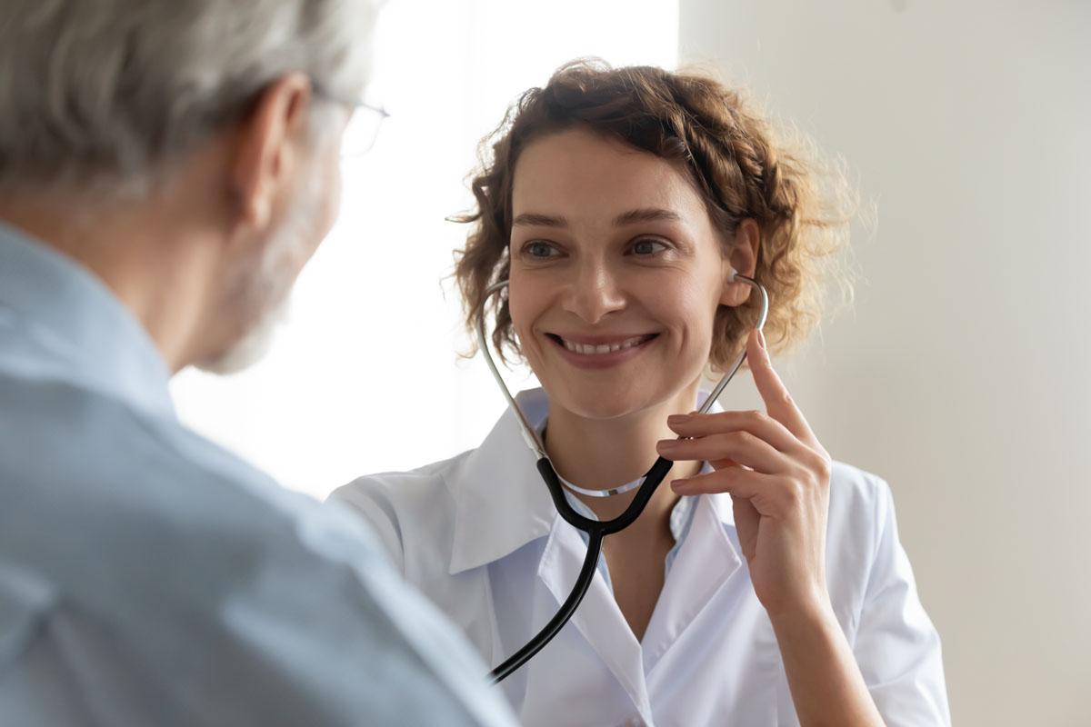 Female doctor with stethoscope listens to patient's heart