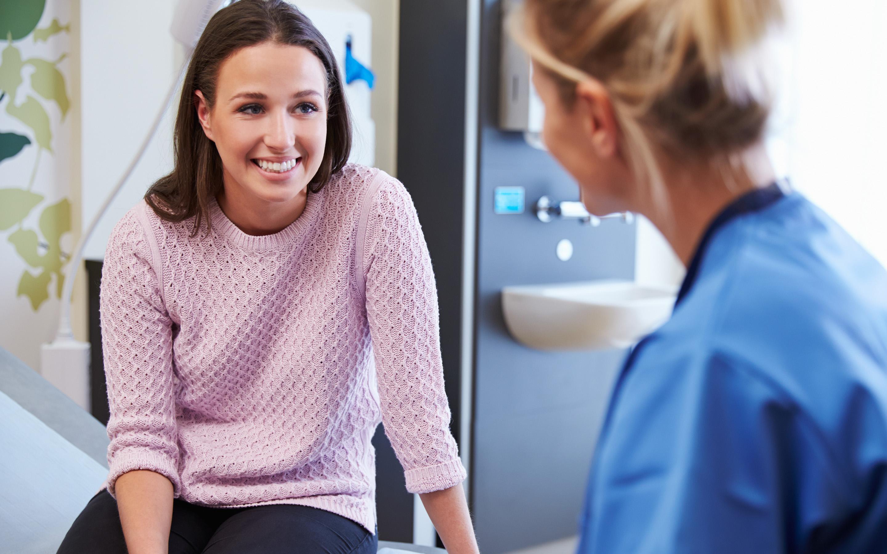 Female patient talking to nurse in a hospital room