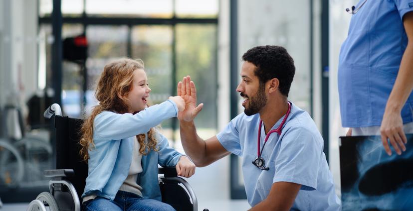 girl in wheelchair high fiving doctor