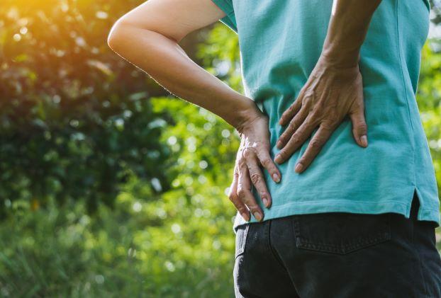 Person holding lower back due to low back pain