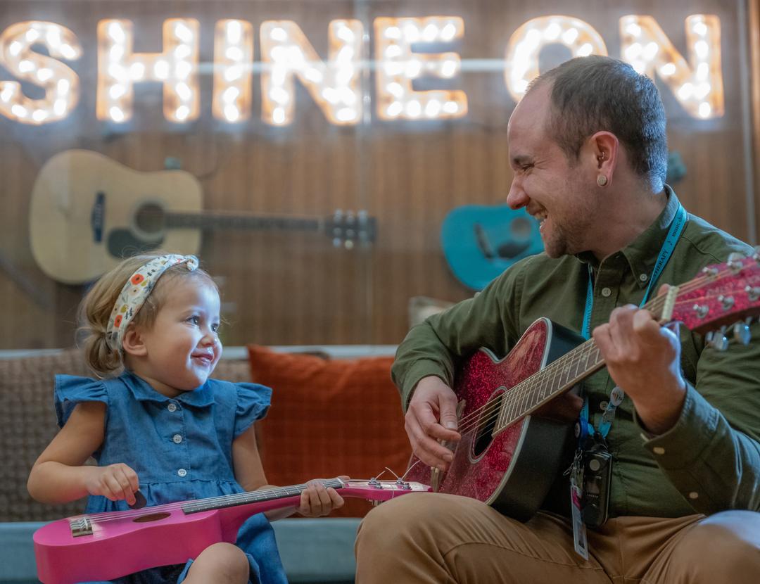 Little girl with guitar and guitar teacher