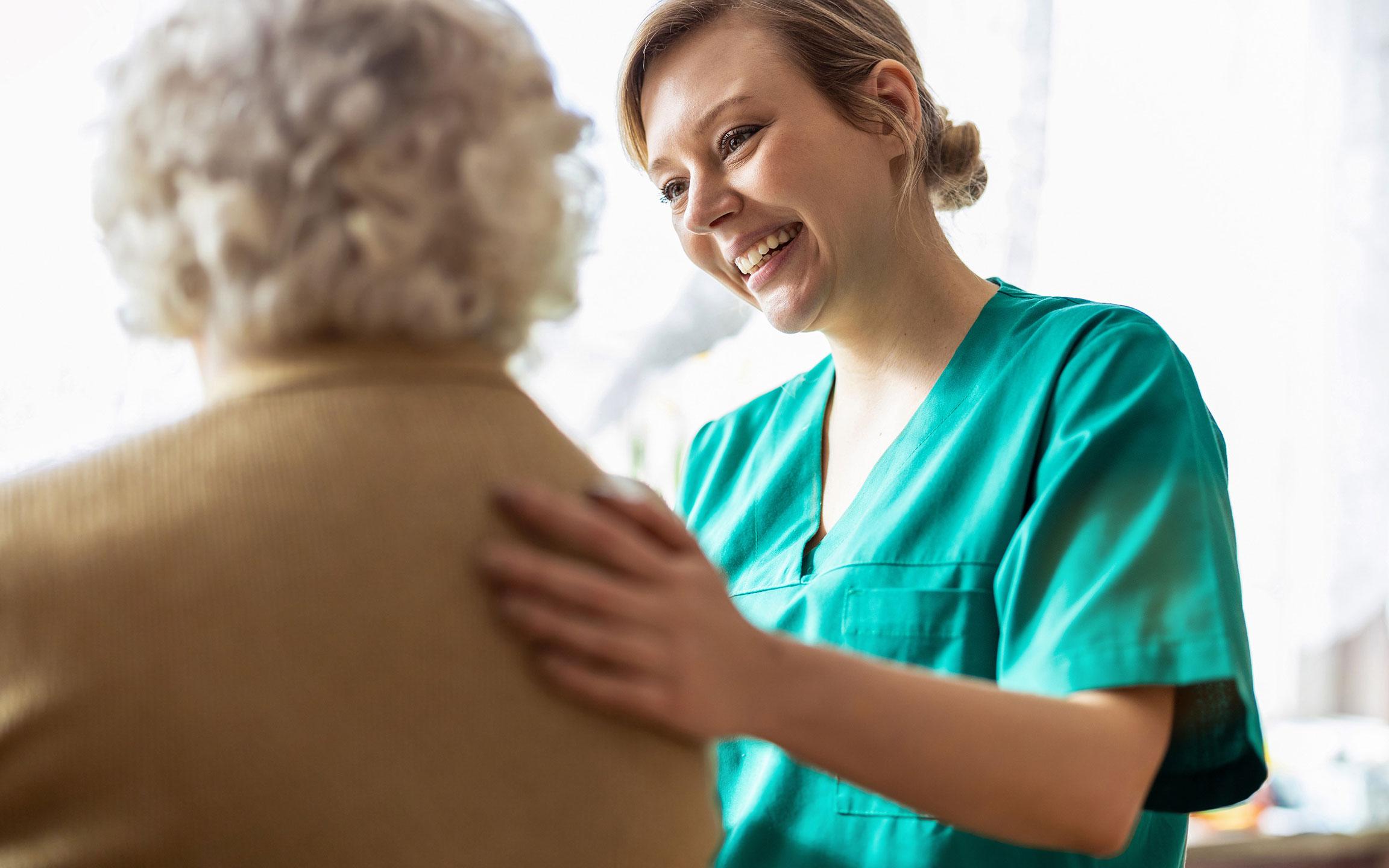 Nurse supporting an elderly lady