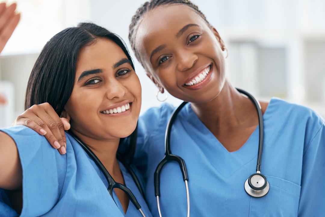 smiling nurses with arms around each other