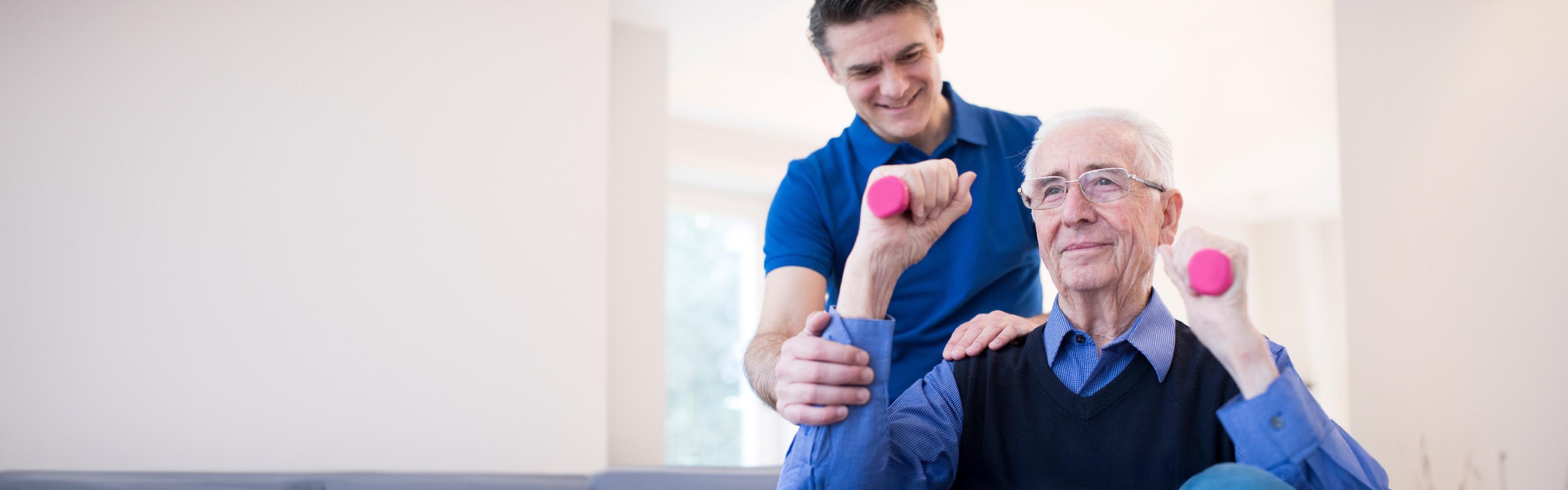 Therapist helping a man lift light weights