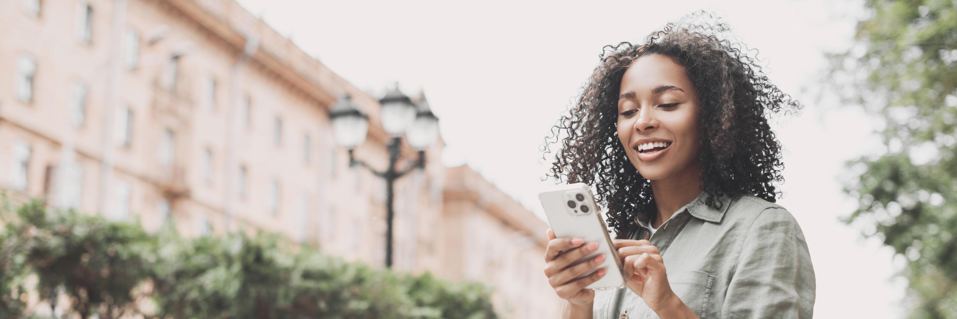 young woman outside with phone