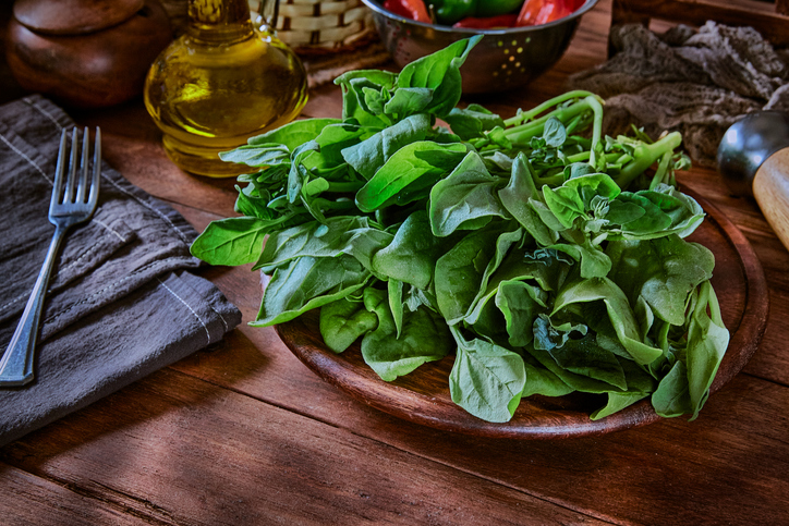 Fresh leaves of spinach on rustic wooden table