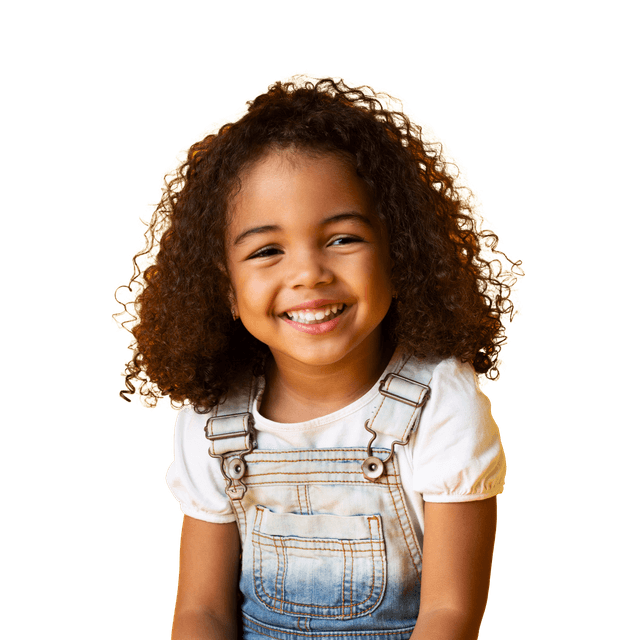 little girl wearing overalls smiling at the camera
