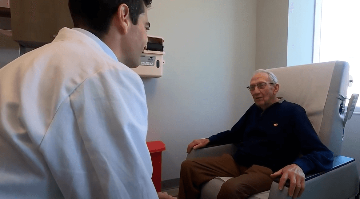 Patient Jerry sitting in chair talking to doctor